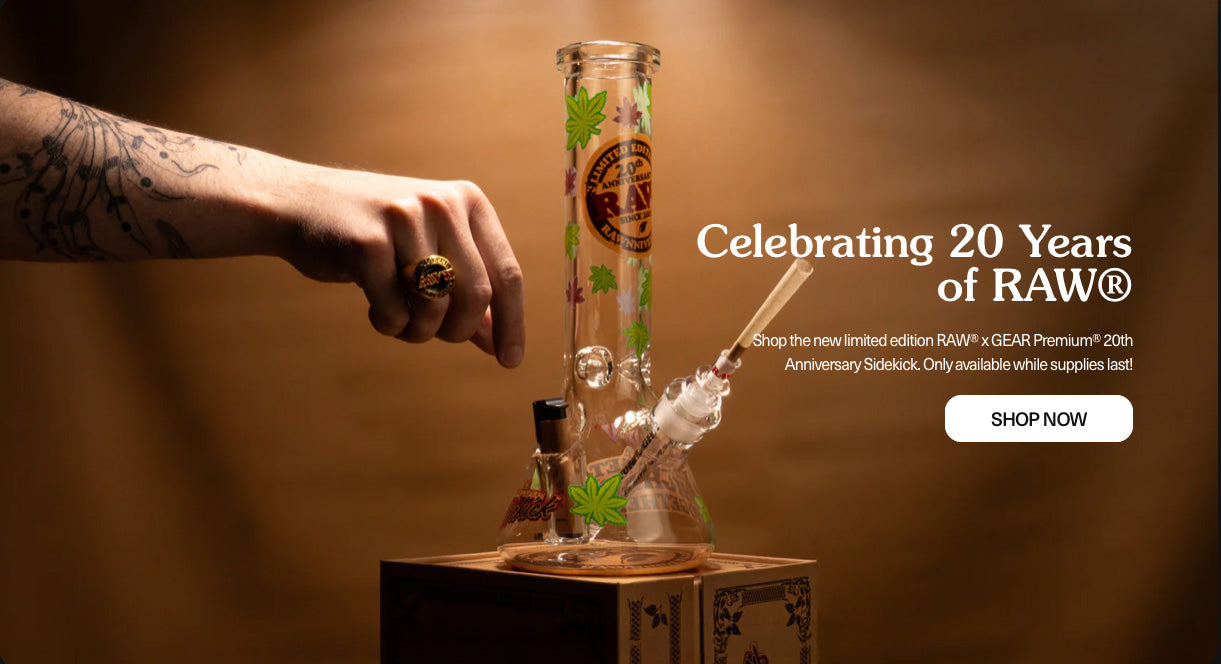 Hand holding a glass pipe with 'RAW' branding, celebrating 20 years of RAW, RAW x GEAR Sidekick 20 Year Anniversary Holster Pipe