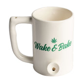 White mug that is also a pipe, has green writing on the front saying "Wake and Bake"